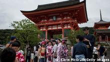 KYOTO, JAPAN - SEPTEMBER 07: Tourists dressed in traditional Japanese outfits pose for photographs in front of the Kiyomizu Temple on September 7, 2015 in Kyoto, Japan. The famous city of Kyoto is going through a massive tourism boom. It recently won the title of World's Best City 2015, for the second consecutive year, in the consumer travel magazine Travel+Leisure, World's Best Awards. The total number of visitors to the city continues to climb year on year and the city has set a goal of achieving 3 million foreign tourists, equating to a tourist spend of 1 trillion yen (approx. $12 billion USD) by the time the Olympics arrive in 2020. However, such a surge in tourist numbers does not come without problems and recently, Kyoto city released two etiquette manuals to help tourists behave respectfully. The manuals, one for How to use a toilet and the Akimahen (Don'ts of Kyoto) use cartoons and emoji's to explain 18 rules of correct tourist behavior, some of which include, where to smoke, when to take your shoes off, where and when you are able to take photographs and how to act appropriately at temples and shrines. (Photo by Chris McGrath/Getty Images)