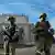 Zwei russische Soldaten stehen am Eingang des Wasserkraftwerks Kachowka 