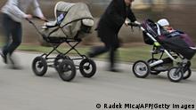 leicht unscharfer Blick auf zwei Kinderwagen, die jeweils von einem laufenden Mann geschoben werden, im vorderen Kinderwagen sitzt ein kleines Kind