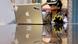A teenager is seen wearing virtual reality devices on his eyes and left hand as he works from home