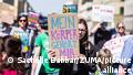 A woman holds up a sign that reads, in German, My Body Belongs to Me