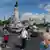 People are seen wearing masks walking near the monument to the Marquis of Pombal in Lisbon, Portugal