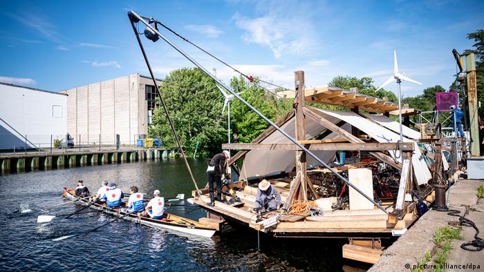 Ein Boot aus einem umgedrehten Hausdach fährt auf einem Kanal