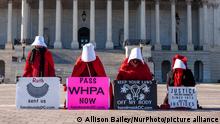 Demonstrators dressed as handmaids from The Handmaid's Tale kneel in protest for reproductive rights in front of the the US Capitol ahead of the arguments in Dobbs v. Jackson Women's Health Organization before the Supreme Court on December 1. (Photo by Allison Bailey/NurPhoto)