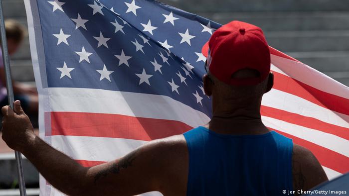 Mann hält amerikanische Flagge hoch an Demonstration im US-Bundesstaat Kentucky 2021
