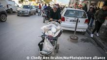 An elderly man pushes a cart in the street of a tough neighborhood of the popular city of Ettadhamen, which is one of the most populated cities in the capital Tunis. Ettadhamen City whose name means âsolidarityâ, was formed by the waves of internal migration (poor, small farmers and unemployed) that marked Tunisia in the early 1950s. The neighborhood's youth played a central role in the 2011 revolution which overthrew President Zine el-Abidine Ben Ali. Since then, the situation has worsened: precariousness, poverty, increase in cost of living, unemployment, school dropout, drug use, hopelessness, marginalization, public's lack of trust in politicians, political, social and economic crisis, social injustice and a suffering public service. This situation has been aggravated by the lockdowns and curfews imposed by the authorities in bid to contain the spread of COVID-19. From January 15 and for more than a week violent nightly riots break out in Ettadhamen and across several cities in Tunisia, during which youths had clashed with riot police that have arrested more than 1200 of young protesters among them several minors. Tunisia, January 26, 2021. (Photo by Chedly Ben Ibrahim/NurPhoto)