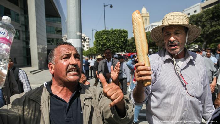 صورة رمزية للفقر في تونس حيث محتج يرفع خبزا في يده في تونس العاصمة 15.05.2022