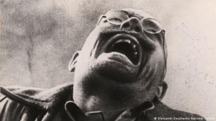 Film still from 'Arsenal': black-and-white photo a man expressively crying to the sky.