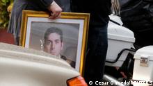 Francisco Pecci, brother of Paraguayan prosecutor Marcelo Pecci who was shot dead during his honeymoon on the island of Baru in Colombia on Tuesday, walks with a person holding a photograph of Marcelo Pecci after the arrival of Pecci's body, in Asuncion, Paraguay May 14, 2022. REUTERS/Cesar Olmedo
