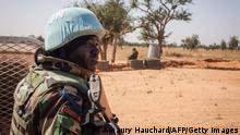 A Senegalese Blue Helmet peacekeeper stands next to United Nations (UN) armoured vehicle in the village of Ogossagou, Mopti Region on November 5, 2021. - Ogossagou village was attacked two times in two years, in 2019 and 2020, by unidentified armed men, that killed in total more than 200 civilians in a village of less that 800 people. (Photo by AMAURY HAUCHARD / AFP) (Photo by AMAURY HAUCHARD/AFP via Getty Images)