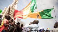 Men wave Malian national flags during a mass demonstration in Bamako, on January 14, 2022, to protest against sanctions imposed on Mali and the Junta by the Economic Community of West African States (ECOWAS). (Photo by FLORENT VERGNES / AFP) (Photo by FLORENT VERGNES/AFP via Getty Images)