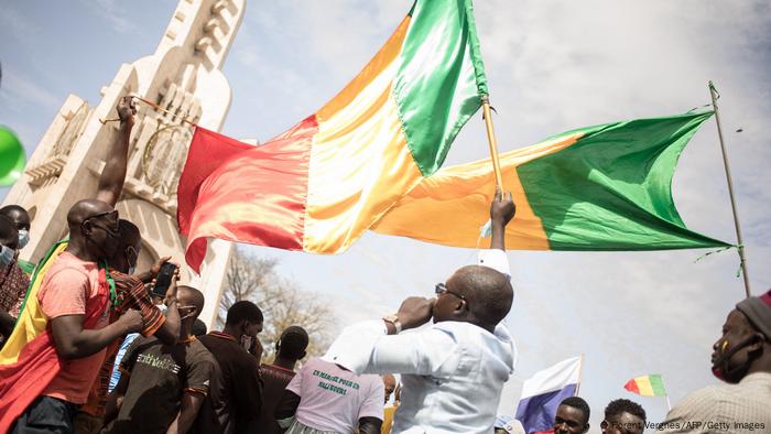 Des manifestants brandissent des drapeaux du Mali