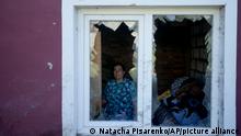 Nastasia Vladimirovna poses for a picture at her home destroyed by attacks in Mostyshche, on the outskirts Kyiv, Ukraine, Monday, June 6, 2022. Vladimirovna lived there with 18 members of her family but now she is staying with her husband on her neighbor's home. (AP Photo/Natacha Pisarenko)