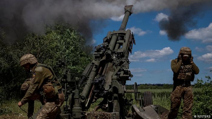 Ukrainian service members fire a shell from a M777 Howitzer near a frontline