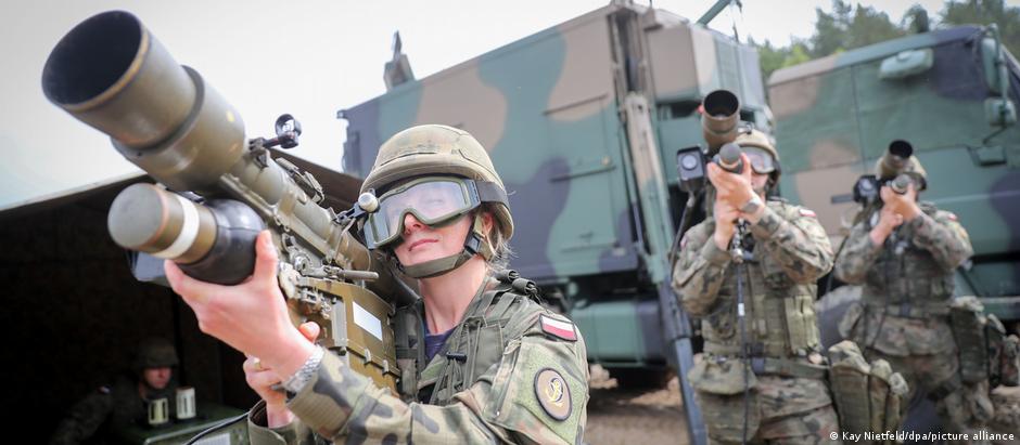 A NATO soldier is seen using a gun.