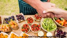 Cropped image of female customer shaking hand with man selling fruits at farm || Modellfreigabe vorhanden
