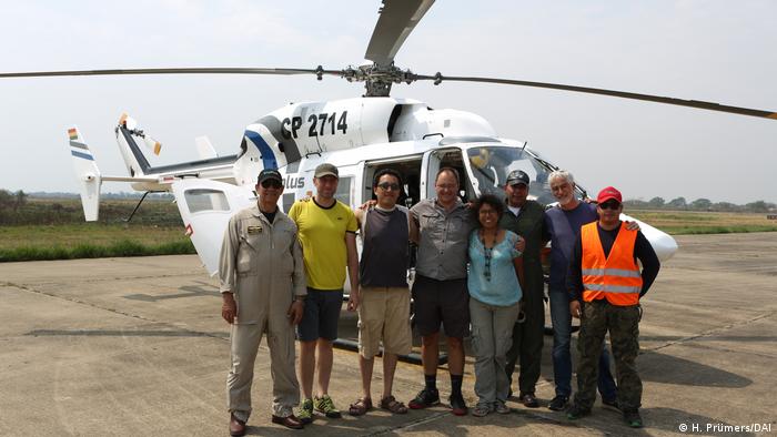 Archäologisches Team vor Helikopter 