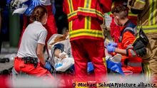 Rescue workers help an injured person after a car crashed into a crowd of people in central Berlin, Germany, Wednesday, June 8, 2022. (AP Photo/Michael Sohn)