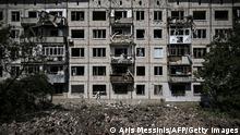 TOPSHOT - A picture shows a crater in front of a damaged apartment building after a missile strike in the city of Soledar, in the eastern Ukrainian region of Donbas on June 4, 2022. - Russian artillery is slamming Ukraine's eastern Donbas region with fierce fighting over the city of Severodonetsk, but the local governor says there was some progress in pushing back invading forces. (Photo by ARIS MESSINIS / AFP) (Photo by ARIS MESSINIS/AFP via Getty Images)