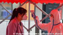 (220606) -- CHANGCHUN, June 6, 2022 (Xinhua) -- An examinee gets her body temperature checked before entering the examination site to get familiar with the enviroment ahead of the national college entrance exam in Changchun, northeast China's Jilin Province, June 6, 2022. A new high of 11.93 million students will take China's national college entrance exam for 2022, also known as gaokao. Aside from a postponement in Shanghai due to COVID-19, the exam will be held on June 7 and 8 nationwide. (Xinhua/Zhang Nan)