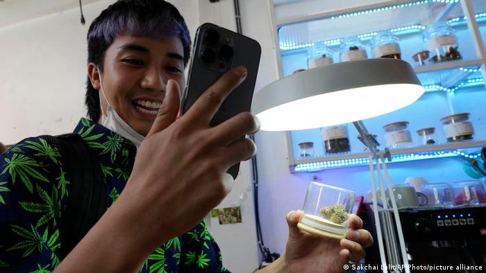 A customer talks on his mobile phone as he buys marijuana at a cafe in Bangkok