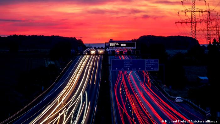 Cars and trucks drive on a highway in Frankfurt, Germany, before sunrise