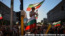 TOPSHOT - A man holds a Bulgarian flag during an anti-government protest in Sofia, on July 29, 2020, as thousands of people have been demanding for weeks, for the resignation of the government which they accuse of protecting the oligarchy. (Photo by NIKOLAY DOYCHINOV / AFP) (Photo by NIKOLAY DOYCHINOV/AFP via Getty Images)