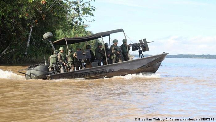 A boat full of armed soldiers on a search and rescue mission on the Amazon River