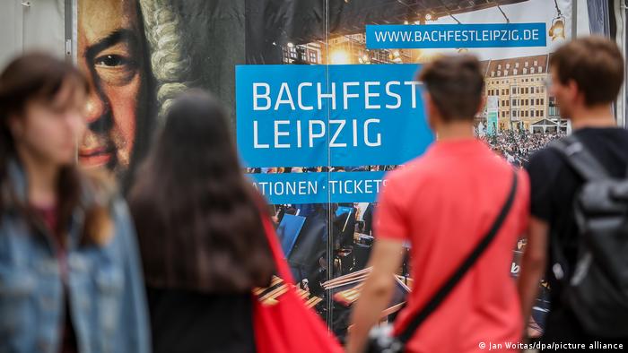 People walk past a Bachfest Leipzig poster