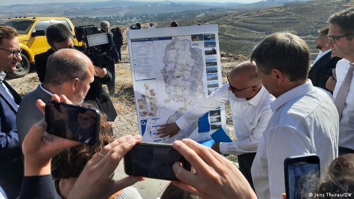Robert Habeck and journalists being shown a map in the West Bank hills