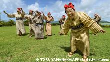 22.6.2015, Kohama Island, Okinawa, Japan, TO GO WITH AFP STORY BY ALASTAIR HIMMER
In this picture taken on June 22, 2015, an elderly women troupe of singers and dancers from Kohama Island in Okinawa wearing traditional local costumes perform at a herb garden on Kohama Island, Okinawa Prefecture. They joke about knocking on heaven's door, but a Japanese 'girl band' named KBG84, with an average age of 84 have struck a blow for grannies everywhere by becoming pop idols. AFP PHOTO / Toru YAMANAKA (Photo credit should read TORU YAMANAKA/AFP via Getty Images)