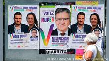 A woman walks past election posters reading Melenchon Prime Minister, for the alliance of leftist parties cobbled together by hard-left leader Jean-Luc Melenchon, in Saint Jean de Luz, southwestern France, Friday, June 10, 2022. Leftist parties that had nearly disappeared from the French political landscape have grown wings in the run-up to Sunday's legislative elections and now threaten to weaken French President Emmanuel Macron. (AP Photo/Bob Edme)