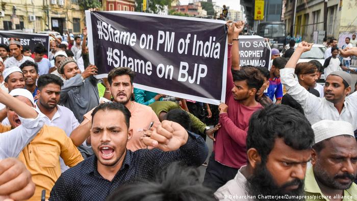 Protesters in India carrying a sign that reads Shame on PM of India, Shame on BJP