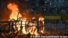 Overturned handcarts are seen in flames following a protest against former India's Bharatiya Janata Party spokeswoman Nupur Sharma and her remarks about Prophet Mohammed, in Ranchi on June 10, 2022. (Photo by Rajesh KUMAR / AFP) (Photo by RAJESH KUMAR/AFP via Getty Images)
