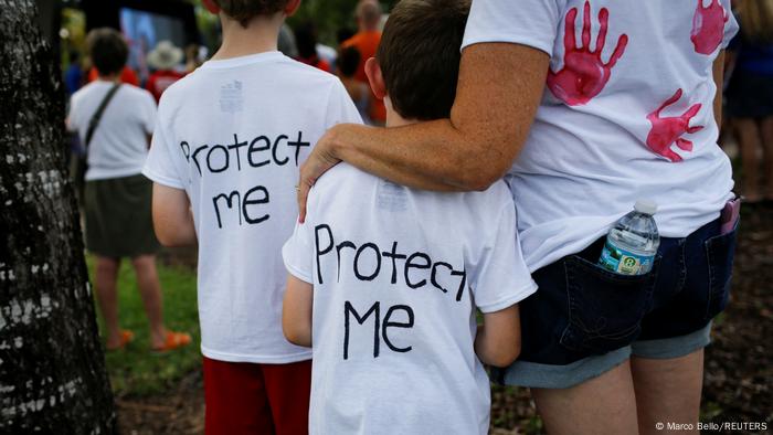 A woman hugs a boy as they take part in a March for our lives rally for gun control in Parkland