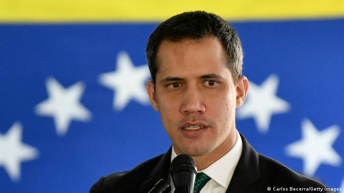 A picture of Juan Guaido in front of a Venezuelan flag