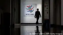 A man walks past a sign of the World Trade Organization at their headquarters on the start of a four-day WTO Ministerial Conference in Geneva on June 12, 2022. - The World Trade Organization gathers ministers in Geneva to tackle pressing issues including global food security threatened by Russia's invasion of Ukraine, overfishing and equitable access to Covid vaccines. (Photo by Fabrice COFFRINI / AFP) (Photo by FABRICE COFFRINI/AFP via Getty Images)