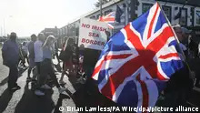 18.06.2021, Belfast - Demonstranten halten britische Fahnen und ein Schild mit der Aufschrift «No Irish Sea Border» («Keine irische See-Grenze») bei einem Protest protestantischer Loyalisten gegen das sogenannte Nordirland-Protokoll. +++ dpa-Bildfunk +++