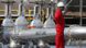 An oil worker standing next to oil pipelines An oil worker standing next to oil pipelines