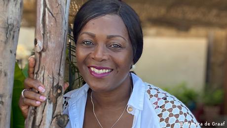  Angèle Etoundi Essamba , woman with hand on a tree trunk smiles into camera 