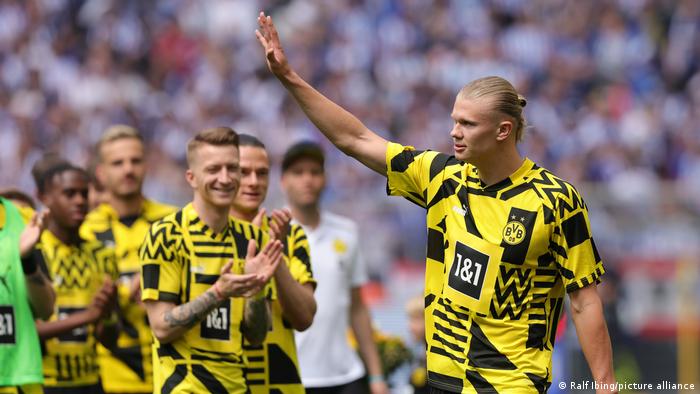 Borussia Dortmunds Stürmer Erling Haaland winkt zu den Fans, während seine Mitspieler ihm applaudieren