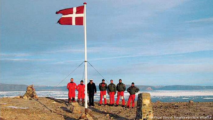 Dies ist - unverkennbar - eine dänische Delegation, die ihre Flagge auf der Hans-Insel gehisst hat. Die Schnapsflasche wurde am Fuße des Flaggenmasts vergraben. 