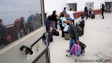Mexican Brigitte Baltazar Lujano (R), a 35 year-old transgender woman, stands next to asylum seekers queueing at the crossing port to enter the United States under humanitarian parole, in Tijuana, Baja California state, Mexico, on June 8, 2022. - Deported last year from the US after living there for 18 years and asylum seeker fleeing from violence herself, Brigitte now works for “Al Otro Lado”, an organization that provides legal and humanitarian support to refugees, deportees, and other migrants in the US and Tijuana. Daily, Brigitte is in charge of receiving, preparing and taking asylum seekers allowed to cross under humanitarian parole in a 24 hour cycle to the crossing port. (Photo by Guillermo Arias / AFP)