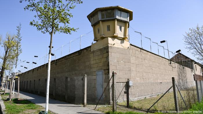 Das ehemalige Stasi-Gefängnis in Berlin-Hohenschönhausen: hohe Mauern, ein Wachturm, Stacheldraht und Scheinwerfer 