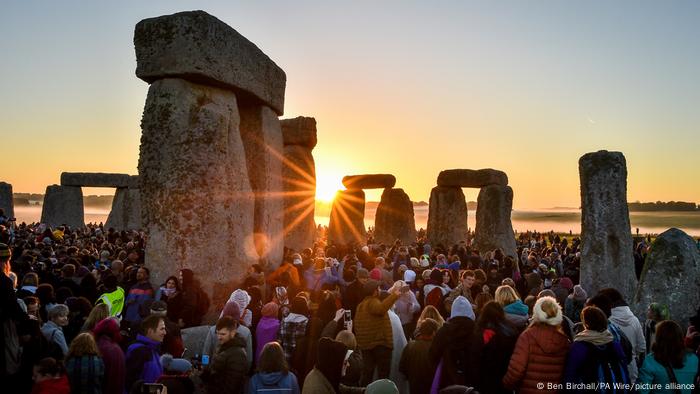 Die Sonne geht zwischen den Steinen am Stonehenge auf, wo sich Massen von Menschen treffen, um die Sommersonnenwende zu feiern.