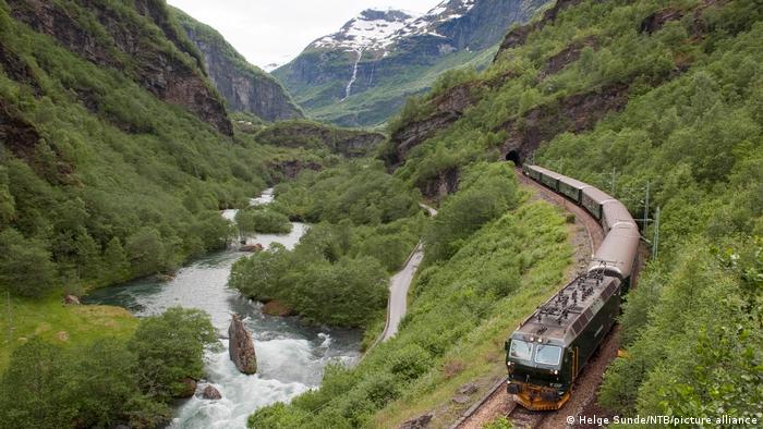 A train passes through a lush green valley