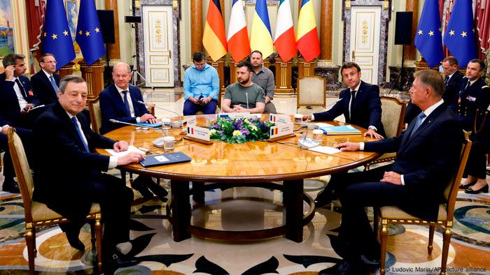 From left to right: Italian Prime Minister Mario Draghi, German Chancellor Olaf Scholz, Ukrainian President Volodymyr Zelenskyy, French President Emmanuel Macron, and Romanian President Klaus Iohannis seated around a table in Kyiv, Ukraine