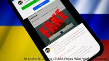 March 17, 2022, Asuncion, Paraguay: Illustration: Ukraine 24 Facebook page is displayed on a smartphone backdropped by cropped waving flags of Ukraine and Russia. Ukraine 24 posted a warning on Facebook that its broadcast and website were hacked on Wednesday. A fake video depicting Ukrainian President Volodymyr Zelenskyy circulated on social media and was placed on Ukraine 24 website by hackers before it was debunked and removed. (Credit Image: Â© Andre M. Chang/ZUMA Press Wire