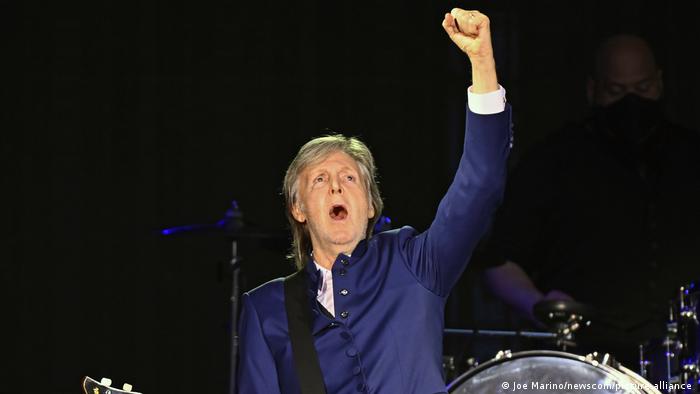 Paul McCartney throws a fist into the air as he begins to perform.