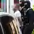 Zwei mit Kapuzenmasken vermummte Polizisten führen einen Mann ab, der bei einer Razzia gegen Drogen-Handel in Berlin festgenommen wurde